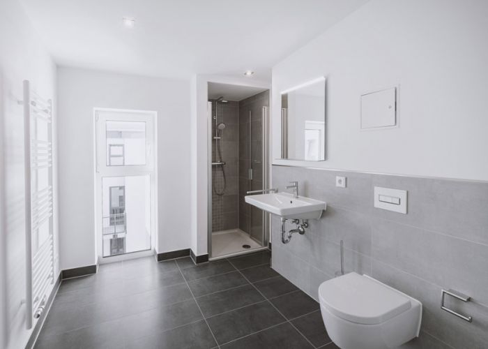 Helles Badezimmer mit Glasdusche, Waschtisch, wandhängendem WC und Handtuchheizkörper von F+S Haustechnik.