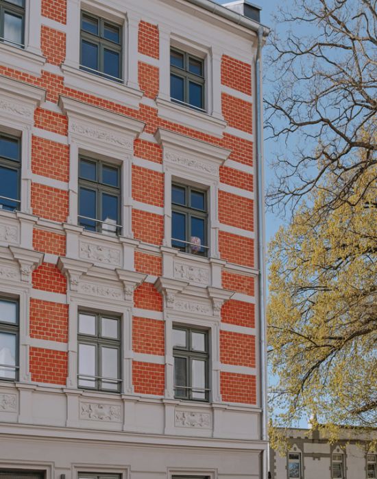 Historisches Mehrfamilienhaus mit roter Backsteinfassade als Referenzobjekt von F+S Haustechnik.