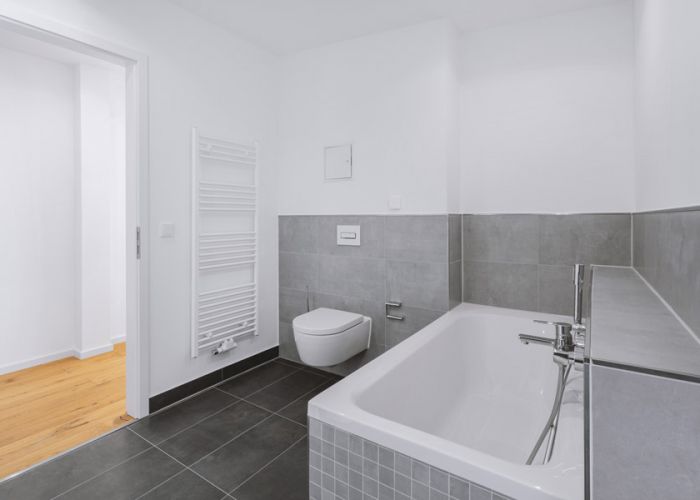 Modernes Badezimmer mit Badewanne, wandhängendem WC und Handtuchheizkörper als Referenz von F+S Haustechnik.