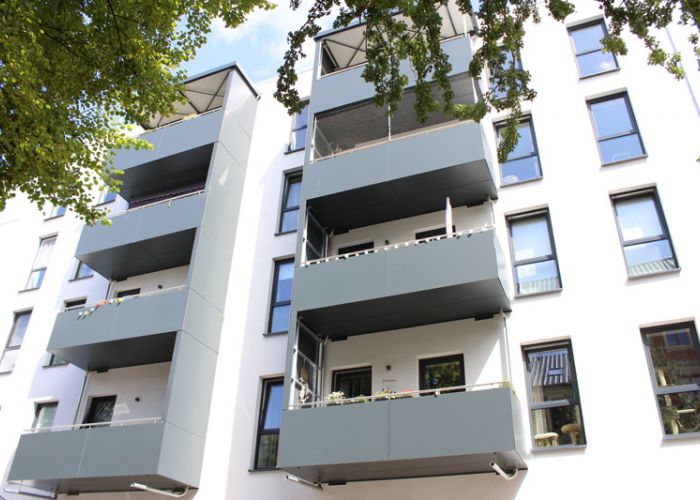 Modernes Mehrfamilienhaus mit grauen Balkonen als Referenzobjekt von F+S Haustechnik.