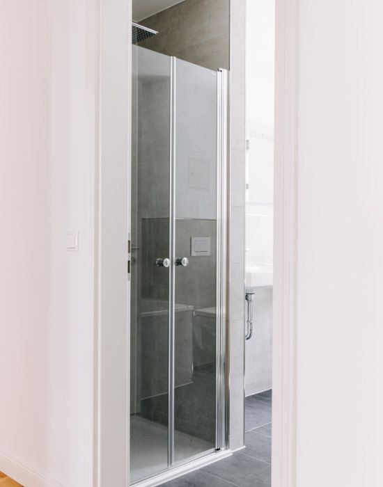 Modernes Badezimmer mit Glasdusche, Regendusche und grauen Fliesen als Referenzprojekt von F+S Haustechnik.
